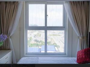 1 dormitorio con ventana grande y cama en Homestay Ha Long luxury (sea ​​view) en Ha Long