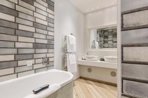 ein Badezimmer mit einer Badewanne, einem Waschbecken und einem Spiegel in der Unterkunft South Lodge in Lower Beeding