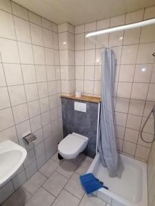 een badkamer met een toilet, een wastafel en een bad bij Pension Gestüt Morgenstern in Hameln
