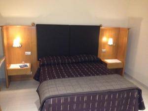 ein Schlafzimmer mit einem großen Bett mit zwei Nachttischen in der Unterkunft B&B Teatro Ristori Verona in Verona