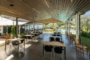 un restaurante con mesas y sillas y una piscina en Agriturismo Costantino en Maida
