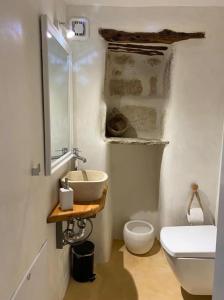 a white bathroom with a sink and a toilet at Little cellar in Chora Folegandros