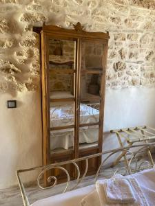 a bedroom with a wooden cabinet and a bed at Little cellar in Chora Folegandros