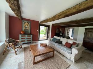 sala de estar con sofá y mesa en Le Logis de la Lettre, en Tinténiac