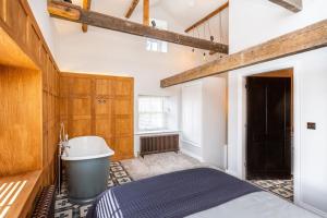 een badkamer met een bed en een bad bij Forrester Cottage, Masham, North Yorkshire in Masham