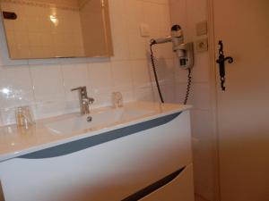 a bathroom with a sink and a phone on the wall at La Ferme de la Gronde in Magny-en-Bessin +84 photos