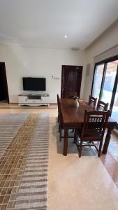 un soggiorno con tavolo, sedie e TV di Al Artaa Resort a Liwa