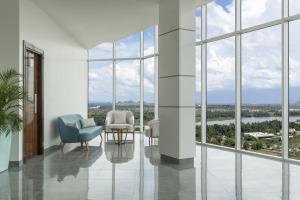 sala de estar con sillas, mesas y ventanas en Pyramid Continental Hotel en Yuba