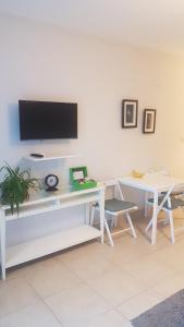 a white desk with a tv on a white wall at Hotel Villa Monte in Cıralı