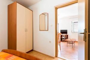 a bedroom with a bed and a closet and a table at House Marina in Rogačić