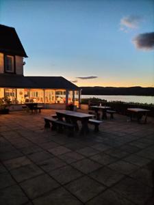 a group of picnic tables in front of a building at Portsonachan Hotel & Lodges in Dalmally