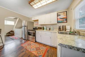 a kitchen with white cabinets and a stainless steel refrigerator at Cozy Chalet Bungalow in Westpark/Cleveland in Cleveland
