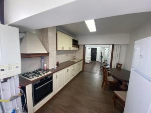 a kitchen with white cabinets and a table in it at Violetta Apartament in Buzău