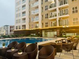 ein Hotel mit Pool, Stühlen und einem Gebäude in der Unterkunft Homestay Ha Long Luxury 3 bedroom (ocean view) in Hạ Long