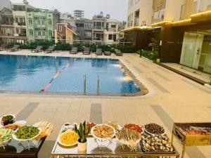 ein Buffet mit Speisen auf einem Tisch neben einem Pool in der Unterkunft Homestay Ha Long Luxury 3 bedroom (ocean view) in Hạ Long
