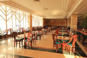 شمس سفاجا ريزورت في الغردقة: غرفة طعام مع طاولات وكراسي ونوافذ