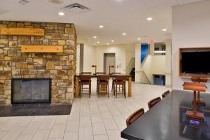 a lobby with a fireplace and a table and chairs at Holiday Inn Express Blowing Rock South, an IHG Hotel in Blowing Rock