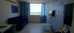 een woonkamer met een blauwe bank en een raam bij Short Term Apartment Tel Aviv Bat Yam 413 in Bat Yam