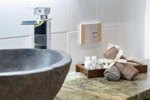 bagno con vasca e lavandino con rubinetto di Varese Suites a Varese