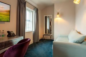 a hotel room with a bed and two chairs at House Bedrooms Dublin in Dublin