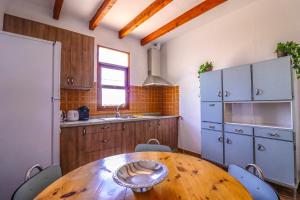 a kitchen with a wooden table and blue cabinets at Rentaliday Casa Saro in Arona