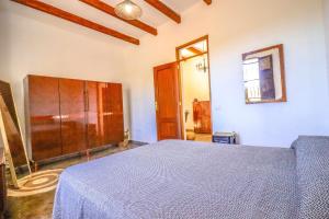 a bedroom with a bed and a wooden cabinet at Rentaliday Casa Saro in Arona