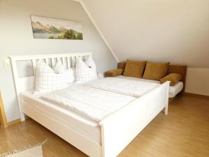 Una cama blanca en una habitación pequeña con en Ferienwohnung Rohlffs Stolpe auf Usedom en Stolpe auf Usedom