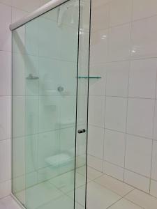 a shower with a glass door in a bathroom at Pousada Marahub in Maragogi