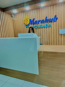 a woman sitting at a desk in a marmaladeossociation office at Pousada Marahub in Maragogi
