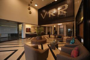 a lobby with couches and chairs in a building at VRR Astoria Hotel & Convention Center in Bangalore