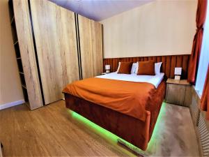 a bedroom with a bed with lights on it at Sirius Confort Kalinderu in Buşteni
