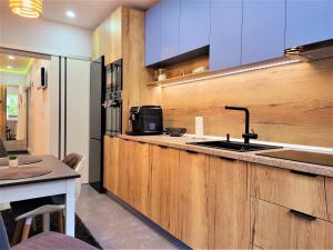 a kitchen with wooden cabinets and a counter top at Sirius Confort Kalinderu in Buşteni