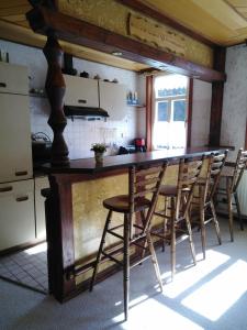 a kitchen with a bar with wooden stools at Haus Bindseil - Ferienwohnung im OG, links in Altenau