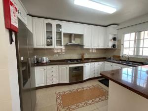 a kitchen with white cabinets and a counter top at villa com piscina entre o mar e as montanhas in Paul do Mar