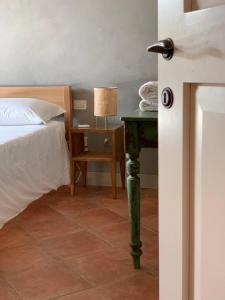 een slaapkamer met een bed en een tafel met een lamp bij Poggiosole in Tavarnelle in Val di Pesa
