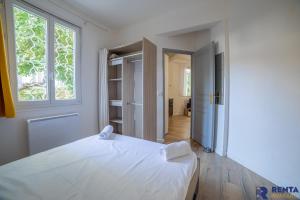 una camera con un letto bianco e una finestra di "Nid douillet" a Antibes