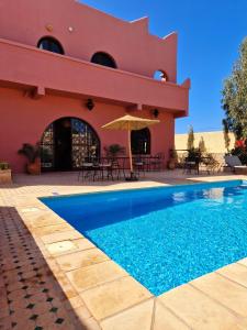 a house with a swimming pool in front of a building at Villa nouran in Ghazoua