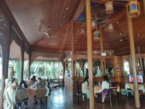 a group of people sitting at tables in a restaurant at Changpuak Hotel in Chiang Mai