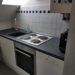 Il comprend une cuisine équipée d'une cuisinière et d'un évier. dans l'établissement Zentrale gemütliche Wohnung, à Cassel