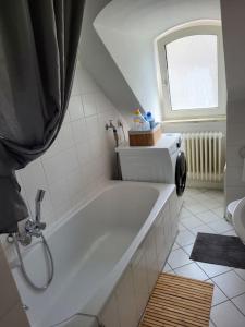 La salle de bains est pourvue d'une baignoire et d'une fenêtre. dans l'établissement Zentrale gemütliche Wohnung, à Cassel
