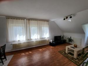 - un salon vide doté de parquet et de grandes fenêtres dans l'établissement Zentrale gemütliche Wohnung, à Cassel