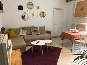 uma sala de estar com um sofá e uma mesa em Gite cosy 25 min Lyon Vienne St Etienne em Longes