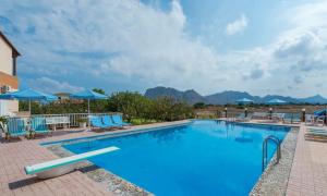 ein großer Pool mit blauen Stühlen und Sonnenschirmen in der Unterkunft Villa Eleana in Chania