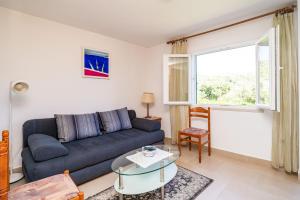 a living room with a blue couch and a window at Apartments Lidija in Zaton