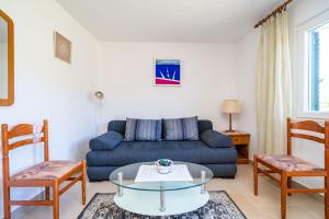 sala de estar con sofá azul y sillas en Apartments Lidija, en Zaton