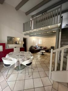 a living room with a table and a loft at "La villa Mariam" Jacuzzi Jardin in Fourques