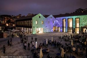 un grupo de personas de pie fuera de un edificio por la noche en Cais de Gaia Historic Loft, en Vila Nova de Gaia