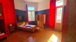Schlafzimmer mit roten Vorhängen und einem Bett in einem Zimmer in der Unterkunft Doukas Hostel Room in Iraklio