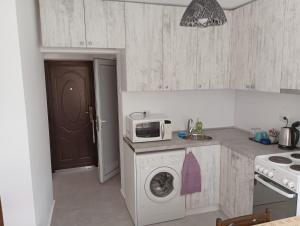 a kitchen with a washing machine and a microwave at Апартамент Ели in Veliko Tŭrnovo