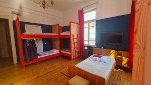 a room with two bunk beds and a flat screen tv at Doukas Hostel Room in Heraklio
